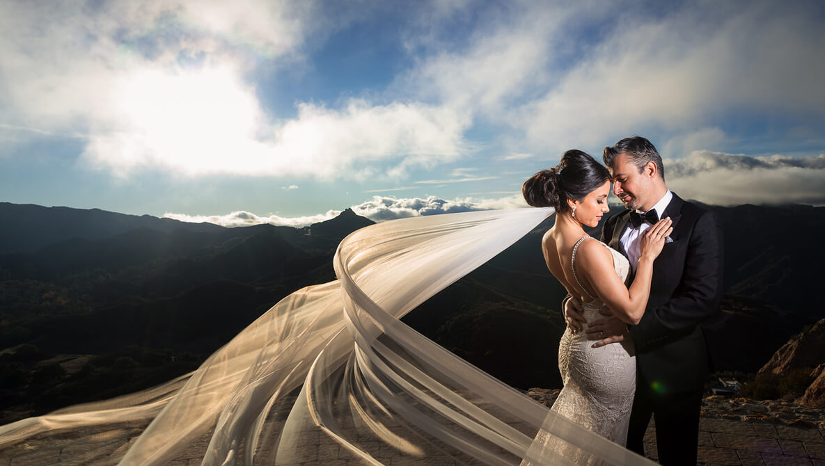 bride and groom pose with veil spread out