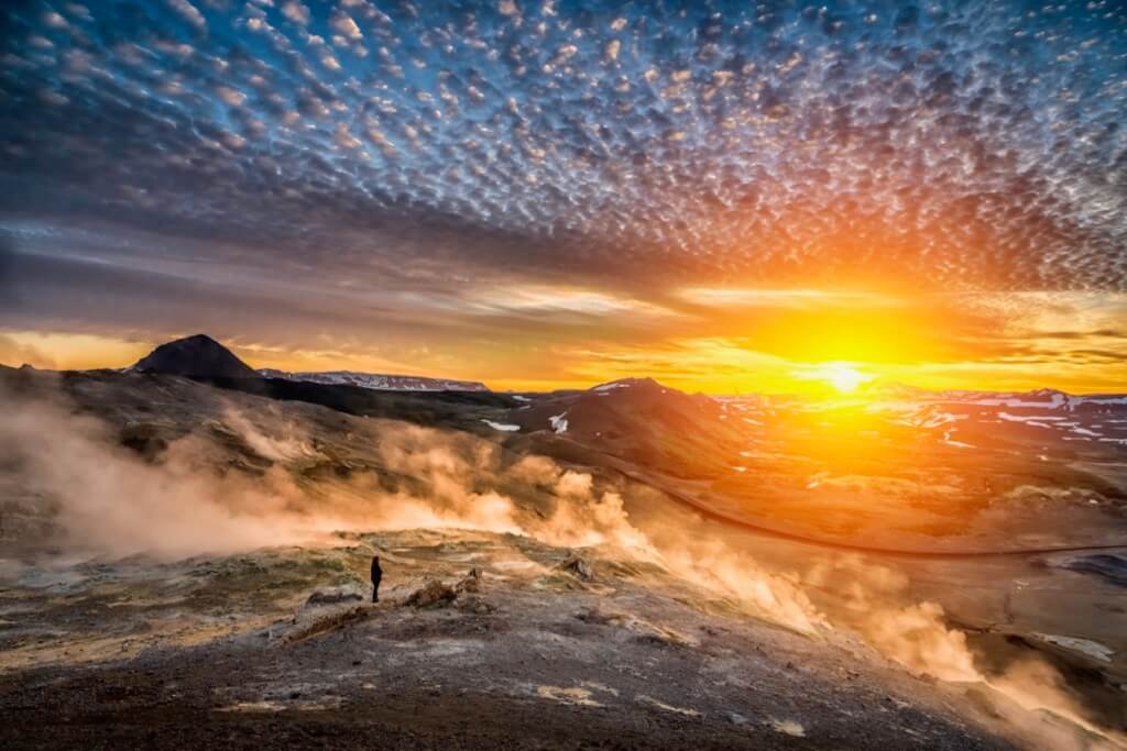 Ragnar TH Sigurdsson - Woman enjoying the mid summer light, midnight sun, Leirhnukur geothermal hot spring area, Mt. Namafjall, Northern Iceland