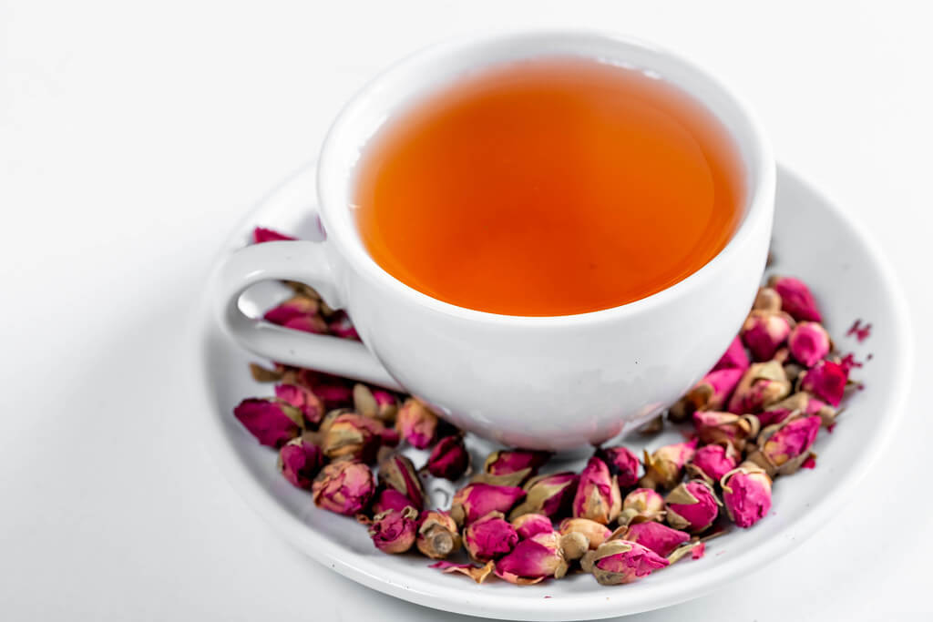 Marco Verch - White Cup of tea and dried rose buds in saucer