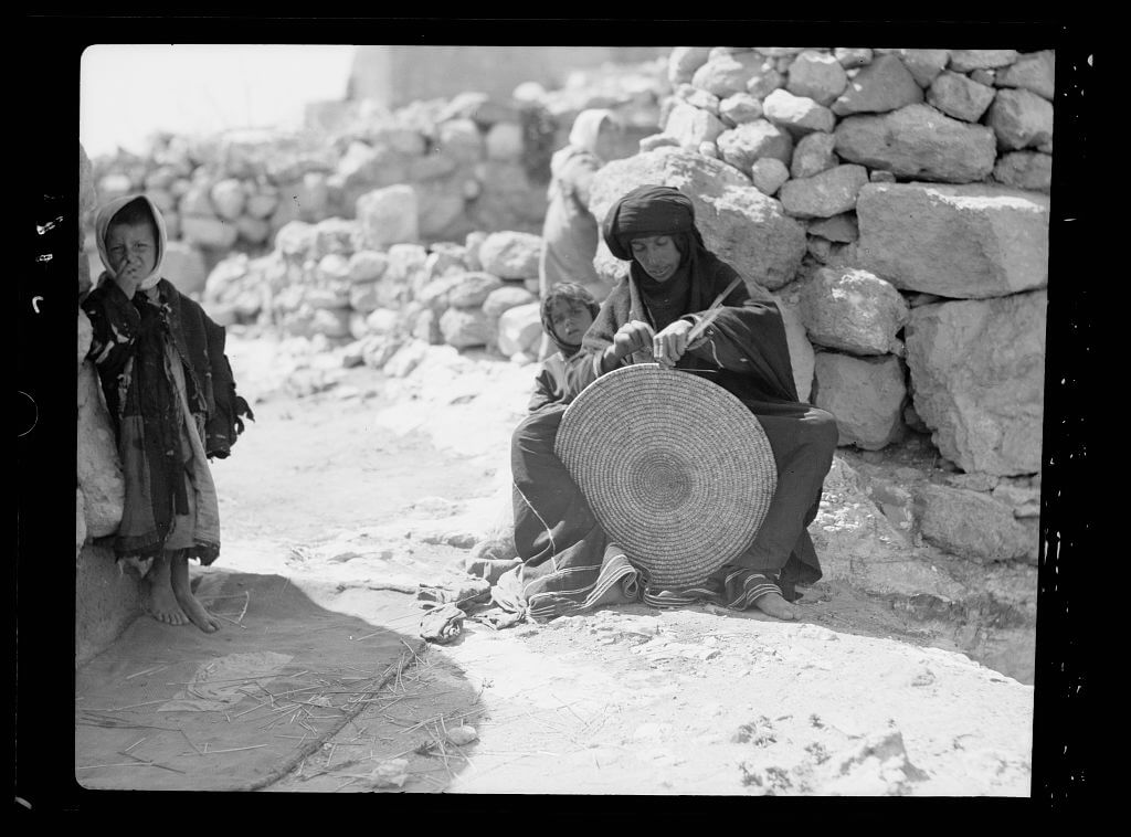 Woman weaving a straw mat