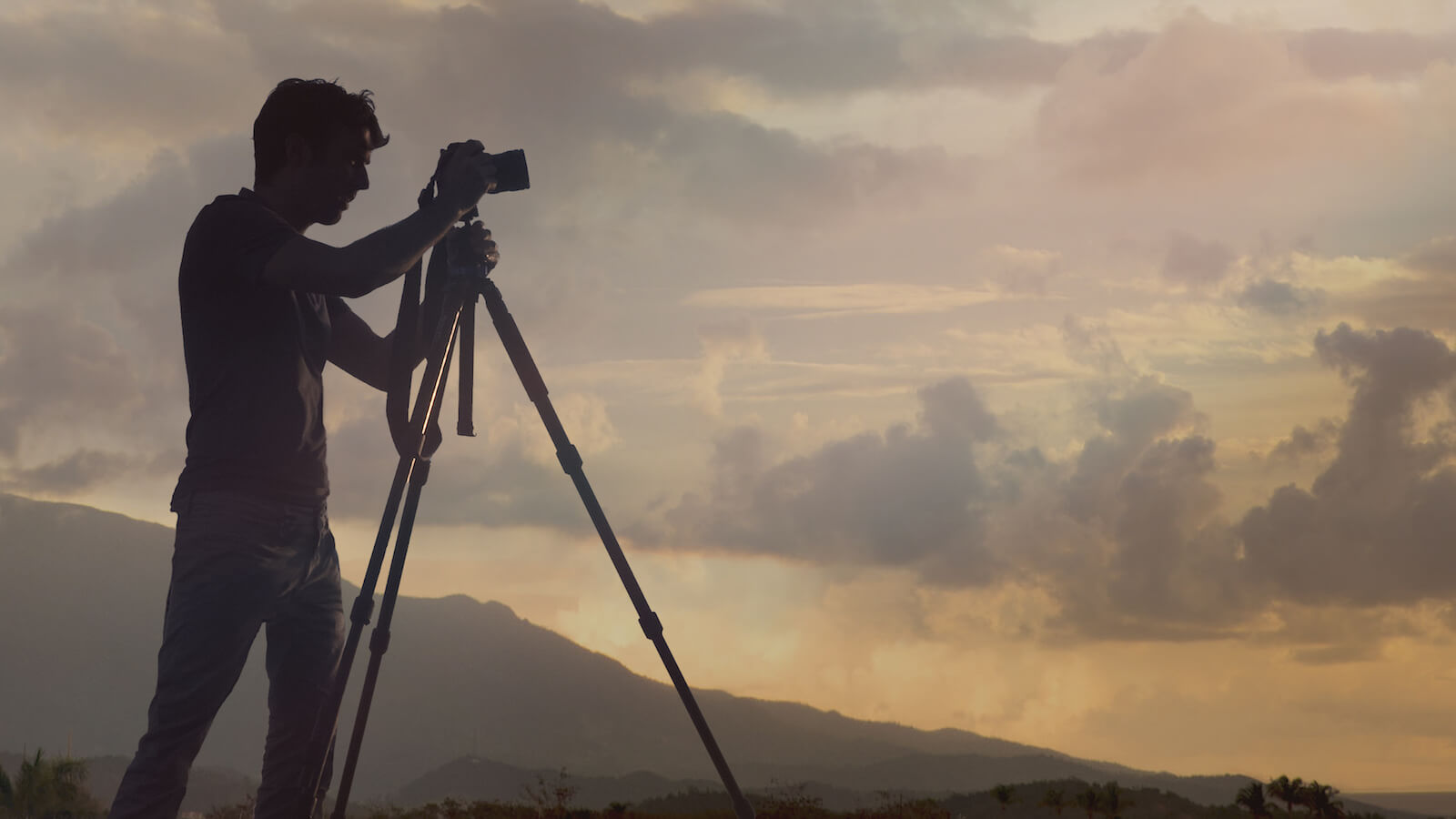 photographer silhouette against cloudy sky at dusk